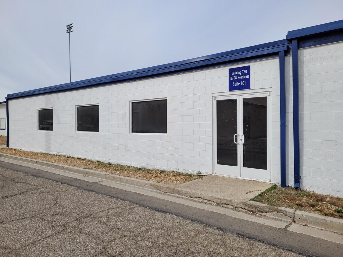 The front of building 720, Suite 101.  the building is white with a blue trim.