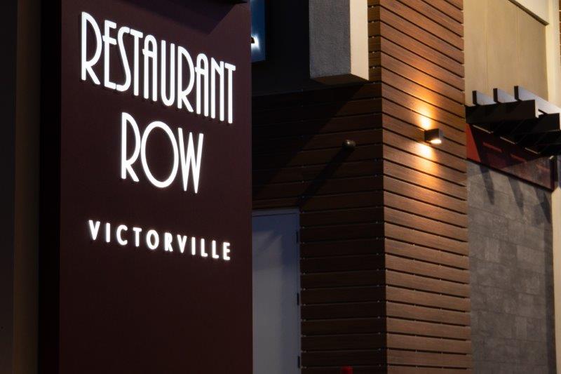 Restaurant row sign at night in Victorville.