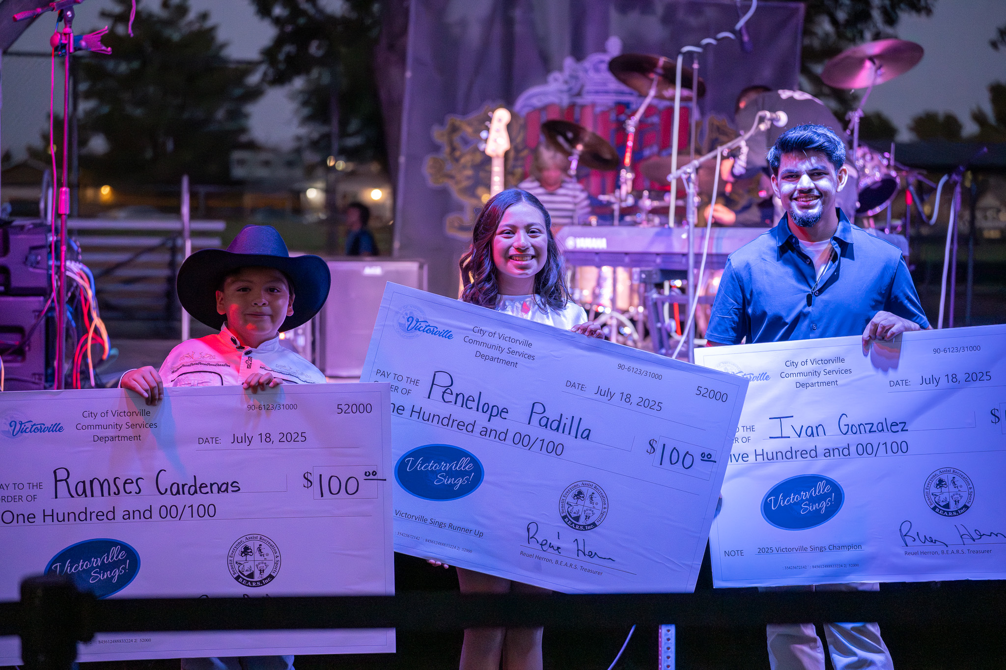 Victorville Sings winners holding checks.