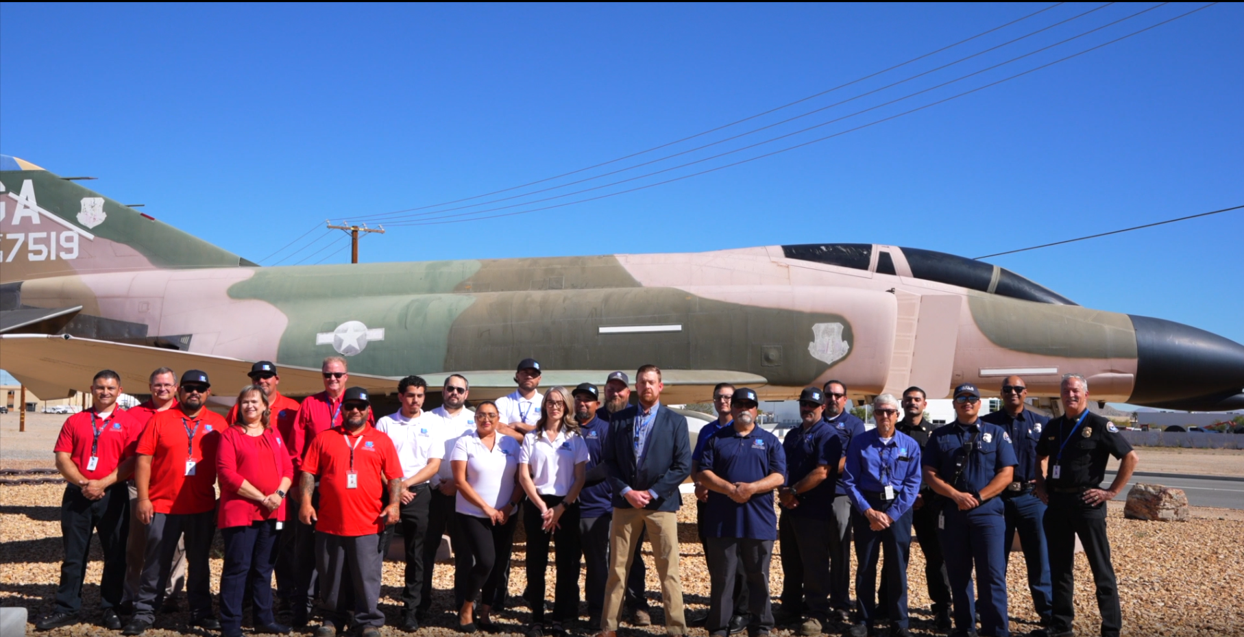A group photo of the SCLA staff in front of the F4 Fighter Jet located on the corner of Phantom West and Cargo Ln.